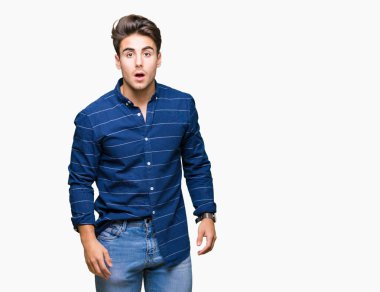 Yakışıklı delikanlı izole arka plan korkuyor ve şok sürpriz ifade, korku ve heyecan yüz üzerinden Donanma gömlek giymiş.