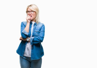 Stresli ve gergin elle çivi ısırma ağzına bakarak izole arka plan üzerinde gözlük takan genç güzel sarışın bir kadın. Anksiyete sorunu.