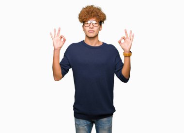 Afro gözlük sakin ol genç yakışıklı adamla ve gülümseyen gözlerle parmak ile meditasyon jest yapıyor kapalı. Yoga kavramı.