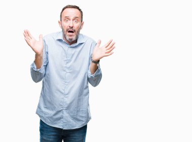 Orta yaş ağarmış üst düzey iş adamı izole arka plan clueless ve şaşkın bir ifadeyle kollar ve eller ortaya çıkar üzerinden. Şüphe kavramı.