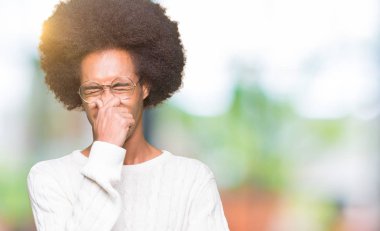 Afrikalı-Amerikalı genç afro saçlı gözlüklü bir şey pis ve iğrenç kokulu, dayanılmaz koku, holding nefes burun parmaklar ile. Kötü kokuyor kavramı.