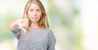 Mutsuz ve kızgın ret gösterilen ve başparmak aşağı hareketi ile negatif seyir izole arka plan üzerinde çizgili süveter giyen güzel genç kadın. Kötü ifade.