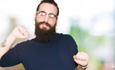 Uzun saç ve sakal geri, germe gözlüklü genç hipster adamla yorgun ve rahat, Uykulu ve erken sabah esneme