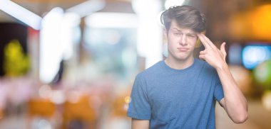 Mavi t-shirt üzerinde izole giyen genç yakışıklı adam arka plan çekim ve öldürmek kendini el ve parmaklara baş, intihar jest işaret.