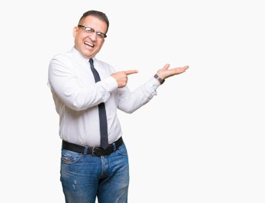 Orta yaş bussines Arap adam gözlüklü üzerinden hayran ve el ile sunulması ve parmak ile işaret ederken kameraya gülümseyen izole arka plan.