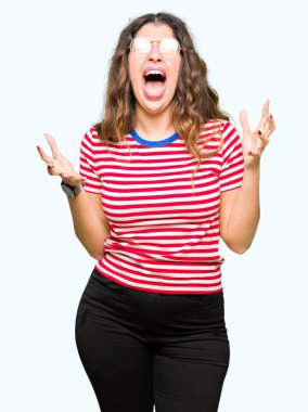 Çılgın ve kızgın bağırarak ve agresif ifade ve silah kaldırdı bağırmaya gözlüklü genç güzel kadın. Hayal kırıklığı kavramı.