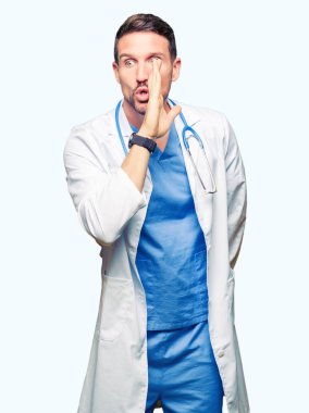 Yakışıklı Doktor adam izole arka plan üzerinde tıbbi üniforma giyen el gizli söylenti, kötü niyetli konuşma konuşma fısıldayarak söylemek dudaklarından