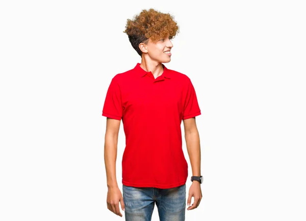 Όμορφος Νεαρός Άφρο Μαλλιά Φορώντας Κόκκινο Shirt Κοιτάζοντας Μακριά Πλευρά — Φωτογραφία Αρχείου