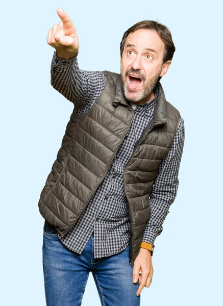 Średnim Wieku Przystojny Mężczyzna Noszenia Zimą Kamizelka Wskazując Palcem Zaskoczony — Zdjęcie stockowe