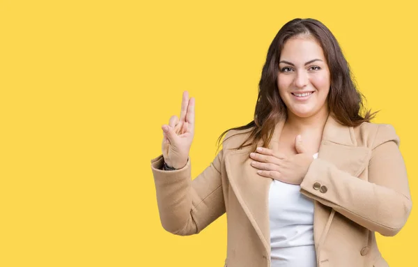 Beautiful plus size young woman wearing winter coat over isolated background Swearing with hand on chest and fingers, making a loyalty promise oath