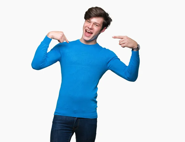 若いハンサムな男の顔に笑顔と自信を持って 誇りと幸せな指で自分を指している孤立した背景に青いセーターを着ています — ストック写真