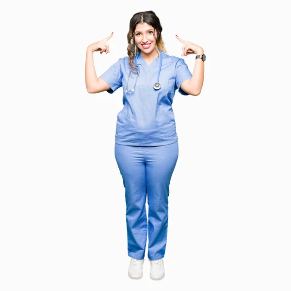 Młody Lekarz Dorosłych Kobieta Sobie Medycznych Smiling Jednolite Wskazując Głowę — Zdjęcie stockowe