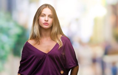 Genç güzel sarışın zarif kadının yüzünde ciddi bir ifade ile izole arka plan üzerinde. Basit ve doğal kameraya bakıyor.