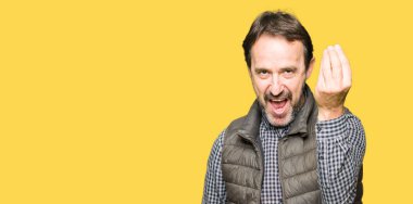 Orta Çağ yakışıklı adam kış yelek giyiyor el ve parmaklar ile Italyan jest yapıyor emin ifade