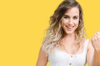 Gülümseyen ve başarı için çığlık genç güzel sarışın kadın izole arka plan çok mutlu ve heyecanlı kaldırdı, silah ile kazanan jest yapıyor. Kutlama kavramı.