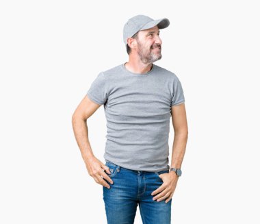 Yakışıklı orta yaş ağarmış kıdemli adam izole arka plan üzerinde yüz, doğal ifade gülümseme ile kenara bakıyor üzerinde spor kap giyiyor. Güven gülüyor.