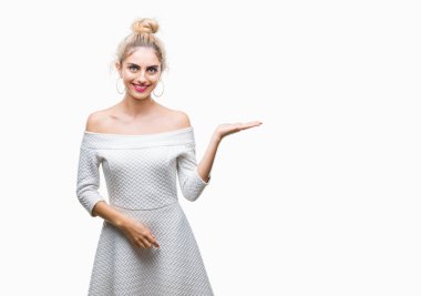 Neşeli sunulması ve kameraya bakarak avucunun ile işaret gülümseyen izole arka plan genç güzel sarışın ve mavi gözlü kadın.