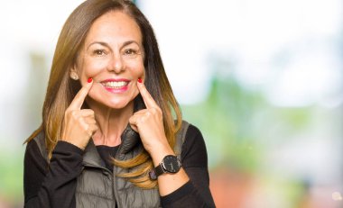 Kış yelek giyen güzel orta yaş kadın gülen açık ağızlı, parmak işaret ve neşeli gülümseme zorlamadan