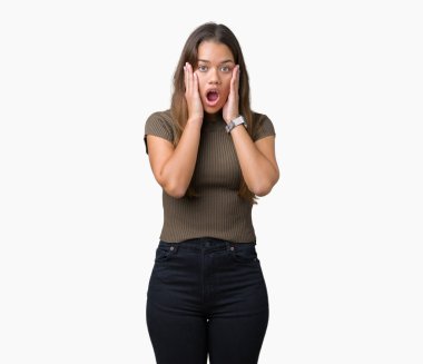 Genç güzel esmer kadın izole arka plan korkuyor ve sürpriz ifade ile şok yüzünden korku ve yüz heyecanlı.