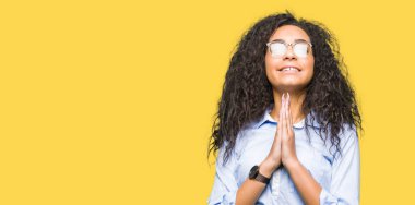 Kıvırcık saçlı Genç güzel iş kızı ellerle birlikte dua gözlük giyiyor affetmek için güven gülümseyen soran.