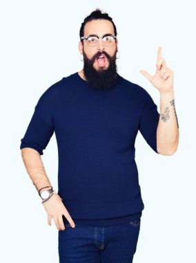 Uzun saç ve sakal başarılı fikirle parmağı yukarıyı gözlüklü genç hipster adam. Çıktıktan ve mutlu. Bir numara.