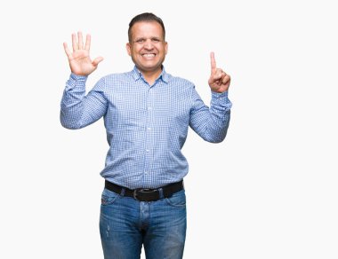 Orta yaş Arap iş adamı gösterilen ve parmakları ile işaret izole arka plan üzerinde kendinden emin ve mutlu gülümseyerek süre 6 numara.