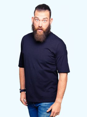 Korkuyor ve şok sürpriz ifade, korku ve heyecan yüz ile rahat t-shirt giyen genç sarışın adam.