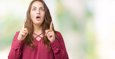 Güzel genç kadın izole arka plan yüzünden hayret ve yukarıya bakıp parmakları ile işaret şaşırttı ve silah kaldırdı boyutu artı.