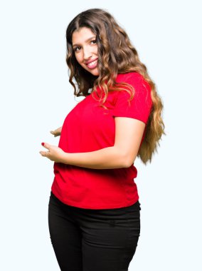 Açık el ile doğal gülümseyen girmek için rahat t-shirt davetkar giyen genç güzel kadın