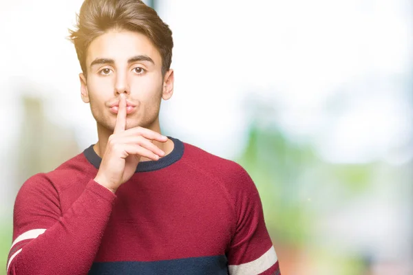 Young handsome man over isolated background asking to be quiet with finger on lips. Silence and secret concept.