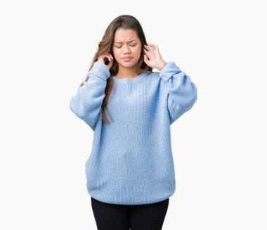 Yüksek sesle müzik gürültü rahatsız ifade parmaklarıyla kulaklarıyla kapsayan izole arka plan üzerinde mavi kış kazak giyen genç güzel esmer kadın. Sağır kavramı.