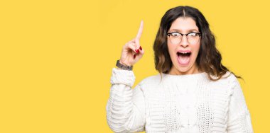 Giyen genç güzel kadın başarılı fikirle işaret parmağı gözlük. Çıktıktan ve mutlu. Bir numara.