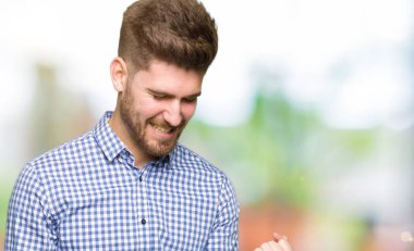 Gülümseyen ve başarı için çığlık genç yakışıklı iş adamı çok mutlu ve heyecanlı kaldırdı, silah ile kazanan jest yapıyor. Kutlama kavramı.