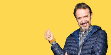 Yanına bir jest yapıyorsun gülümseyen gurur, seyir kış palto giyiyor orta yaş yakışıklı adam yaşasın