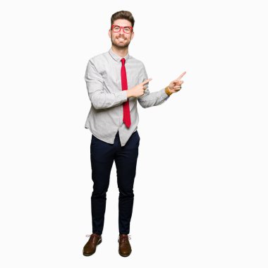 Gülümseyen ve iki elleri ve parmakları ile tarafına işaret kamera bakarak gözlüklü genç yakışıklı iş adamı.