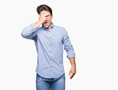 Mahcup ifadeyle parmaklarımın arasından seyir yüz ve gözler el ile kapsayan şok izole arka plan bakmak üzerinde genç yakışıklı iş adamı.