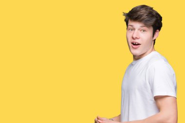 İzole arka plan korkuyor ve şok sürpriz ifade, korku ve heyecan yüz üzerinden Casual beyaz t-shirt giyen genç yakışıklı adam.