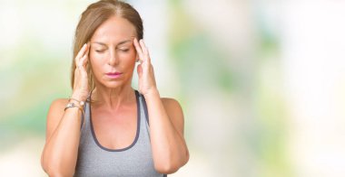 Güzel orta yaş kadın kafa ağrısı için baş el ile izole arka plan üzerinde spor giysileri giyiyor çünkü stres. Migren muzdarip.