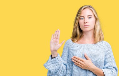 Üzerinde mavi kazak giyen güzel genç kadın izole arka plan göğüs ve bir sadakat sözü yemin yapma avuç, el ile küfür