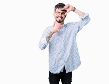 Elle yapma çerçeve ve parmakları ile mutlu yüz gülümseyen izole arka plan üzerinde gözlük takan yakışıklı delikanlı. Yaratıcılık ve Fotoğrafçılık kavramı.