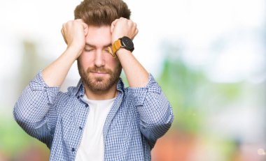 Genç yakışıklı sarışın adam giyiyor rahat gömlek çünkü umutsuz ve stresli baş ağrısı acı acı ve migren. Ellerini kafasına.