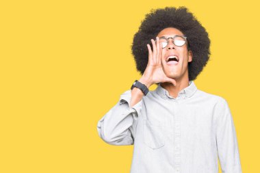 Afrikalı-Amerikalı genç afro saçlı bağırarak ve ağzı üzerinde el ile yan için çığlık gözlük takıyorum. İletişim kavramı.