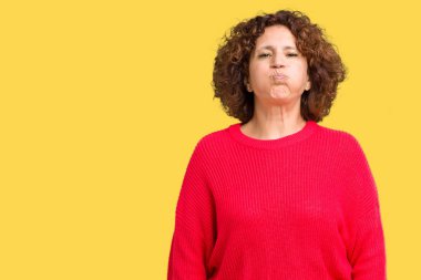 Güzel orta ager üst düzey kadın kırmızı kış kazak komik surat ile yanakları şişirme izole arka plan üzerinde. Ağız ile hava, deli ifade şişirilmiş.