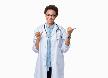 Üzerinde tıbbi ceket giyen genç Afro-Amerikan doktor kadın izole arka plan emin gülümseyen arkasından el ve kadar başparmak ile işaret