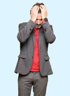 Orta yaş yakışıklı iş adam çünkü umutsuz ve stresli baş ağrısı acı acı ve Migren. Ellerini kafasına.