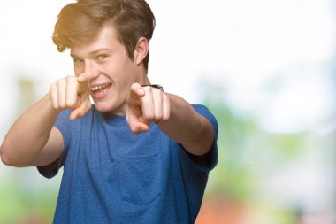 Mavi t-shirt üzerinde izole giyen genç yakışıklı adam arka plan size işaret ve parmaklar, kamerayla olumlu ve neşeli gülümseyen