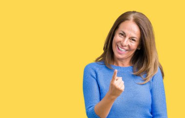 Orta yaş güzel kadın izole arka plan Beckoning üzerinde kış kazak giyen el mutlu ve gülümseyerek davet ile buraya jest gel