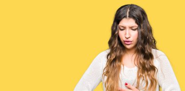 Çünkü mide üzerinde el ile beyaz kazak giyen genç güzel kadın mide bulantısı, ağrılı hastalık hasta hissediyor. Ağrısı kavramı.