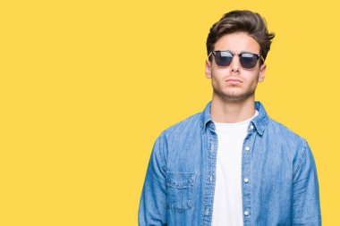 Genç yakışıklı adam sorunu nedeniyle izole arka plan şüpheci ve sinir, papatyanın üzgün üzerinde güneş gözlüğü takıyor. Negatif kişi.