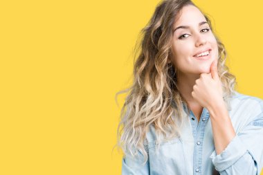 Güzel sarışın genç kadın emin çapraz kollar ve çeneme kaldırdı el ile gülümseme ile kameraya bakarak izole arka plan üzerinde. Pozitif düşünce.